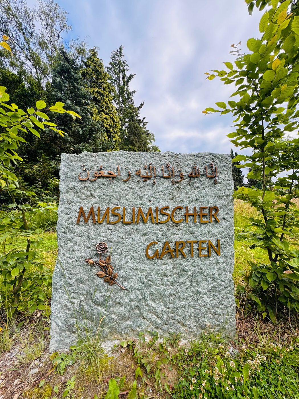 Granitstele mit arabischer Inschrift und der Aufschrift „Muslimischer Garten“ am Eingang des muslimischen Grabfeldes auf dem Evangelischen Friedhof Lauenburg
